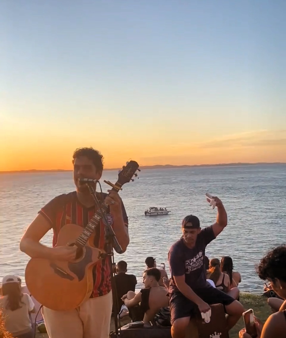 Pôr do sol atrás do Farol da Barra com Banda Geração 80